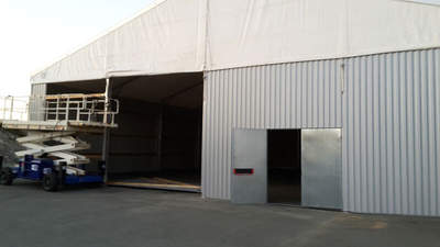 Porte double battants, bardage gris et toit en bâche blanche pour le bâtiment temporaire de Rapidhome